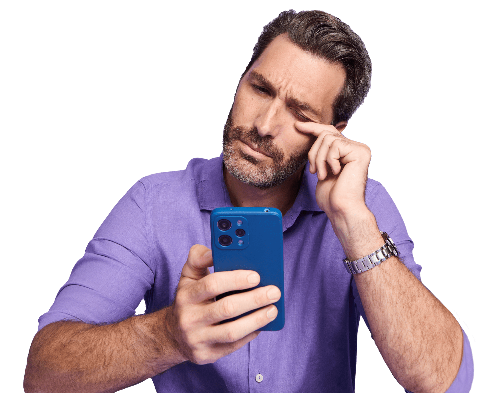 Man in a blue squinting while looking at his phone and rubbing his eye with his index finger